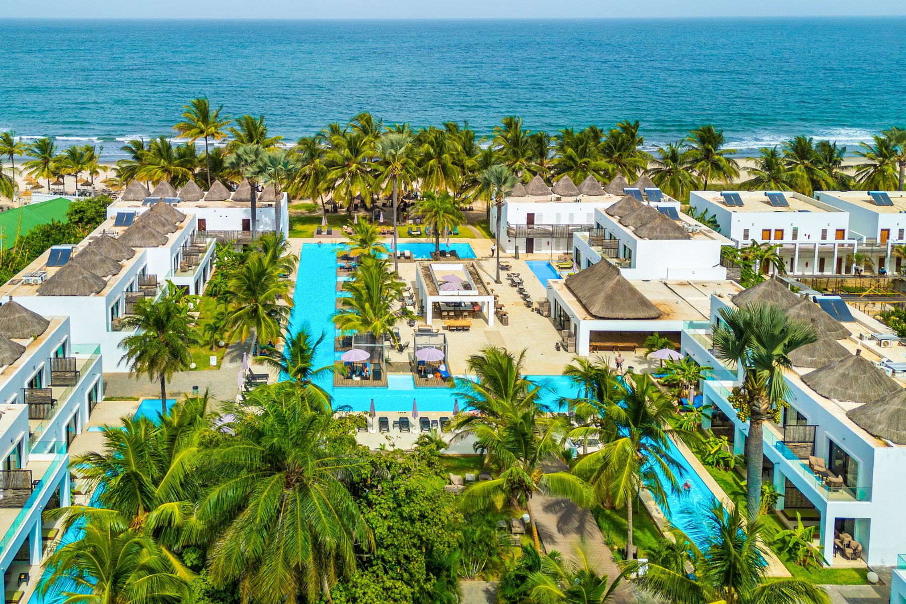 Aerial view of Kalimba Beach Resort on Kotu Beach, showing the pools, resort buildings, palms and Atlantic Ocean